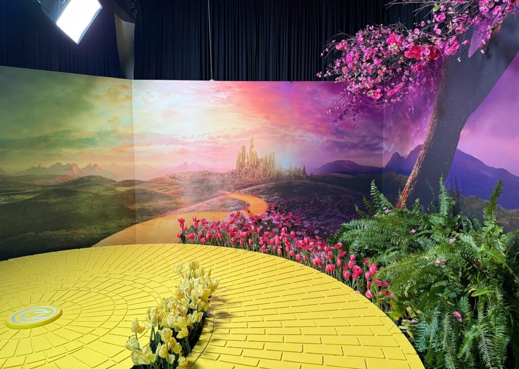 Yellow brick road with cinematic background of the city of Oz and lots of yellow and pink tulips along the road.