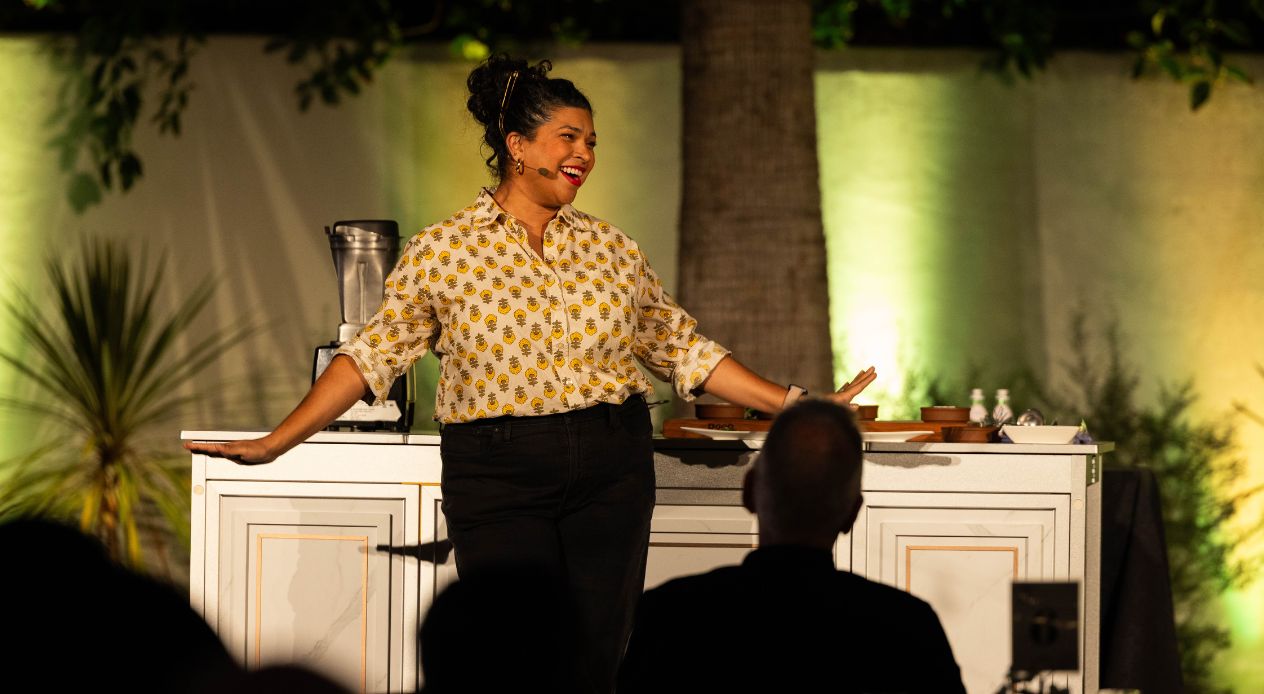 Aarti Sequeira doing a live cooking demo on stage.
